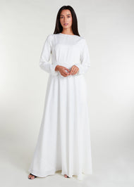 This fully lined white abaya boasts subtle pleats strategically placed at the waist to gently accentuate your figure. An optional belt is included for those who prefer a cinched waist. 